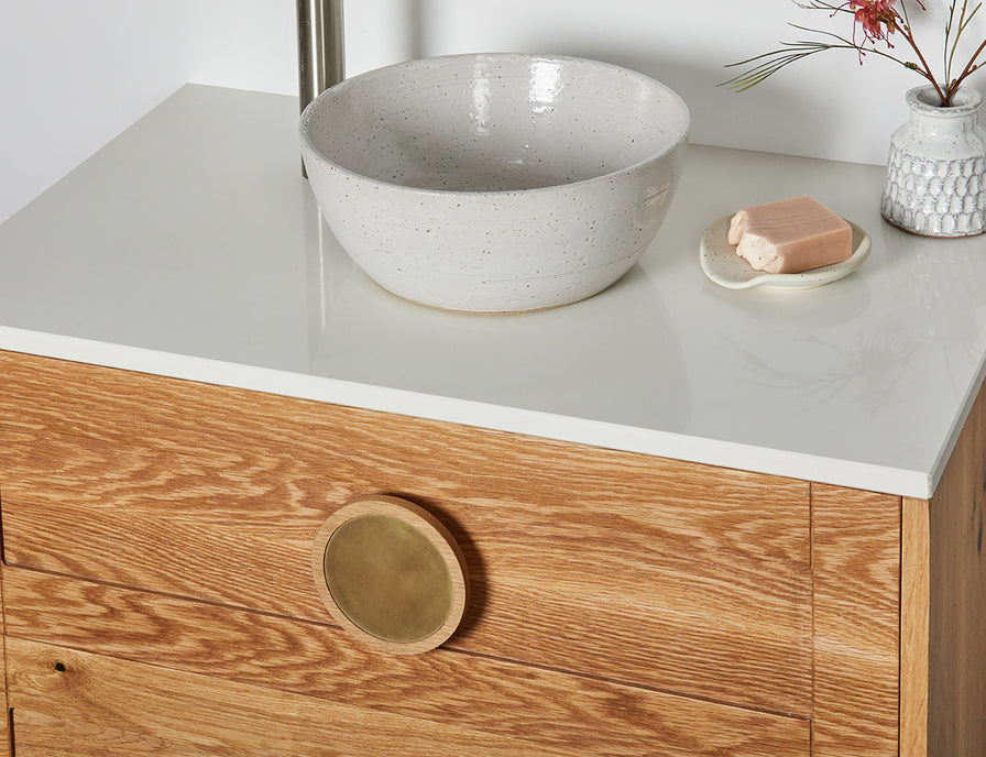 Custom timber vanity with round timber and brass handles and a white stone top 