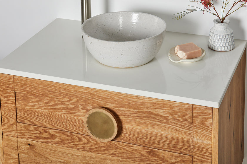 Custom timber vanity with round timber and brass handles and a white stone top 