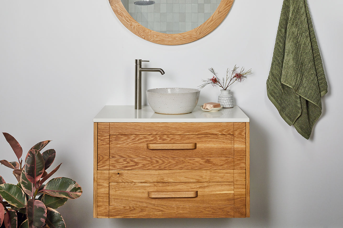 Timber bathroom vanity with shaker style drawers, handles and white stone top