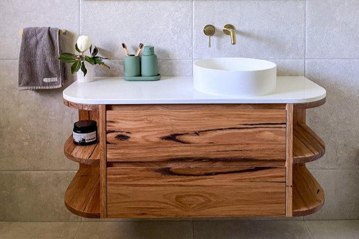 timber wall hung vanity with curved end and a stone top 
